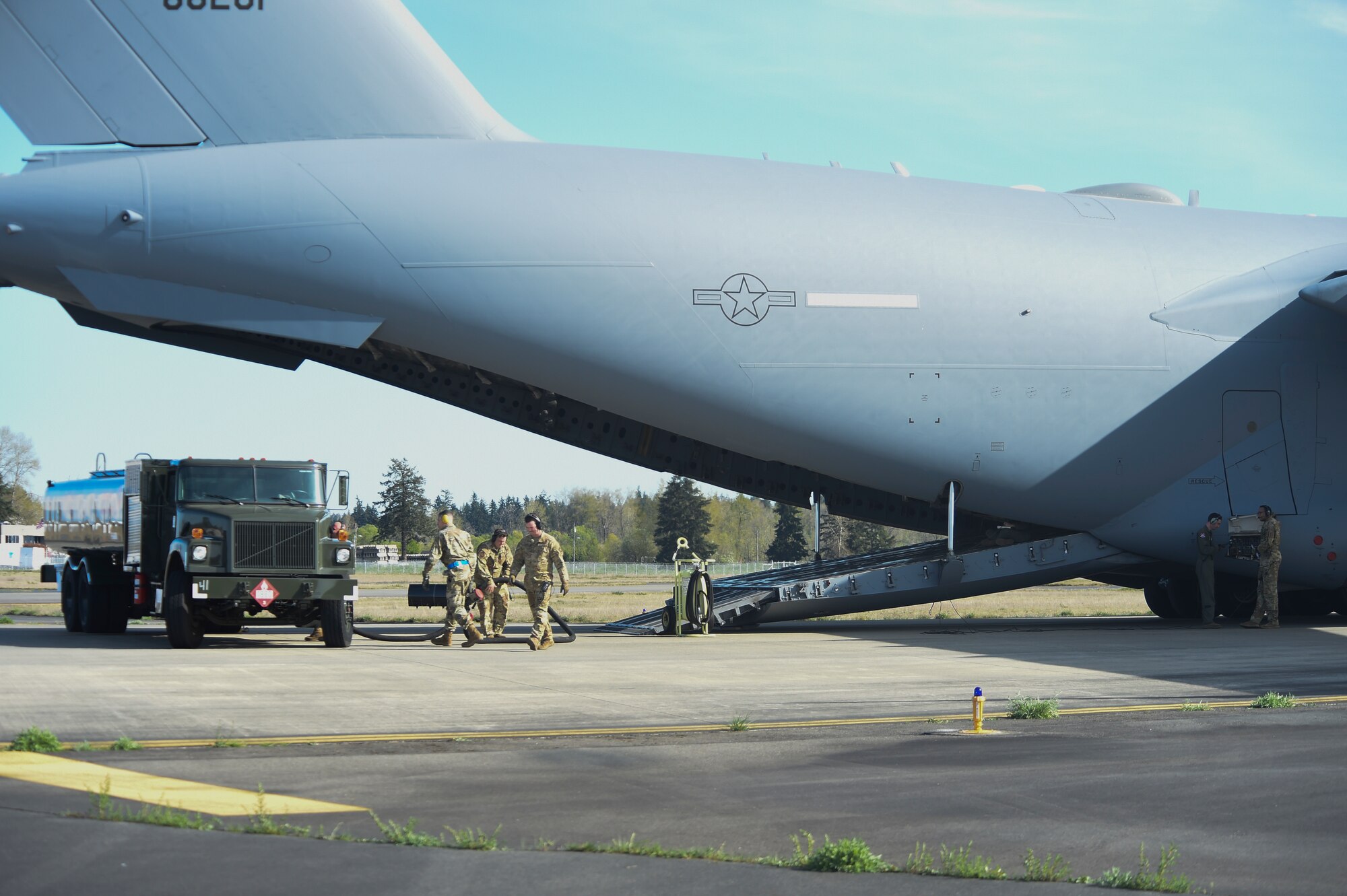 Airmen with the 62nd Airlift Wing and 627th Air Base Group demonstrate a wet-wing defuel procedure on a C-17 Globemaster III at Joint Base Lewis-McChord, Washington, April 21, 2021, as part of Exercise Rainier War. The exercise tests the 62nd AW’s capability to plan, generate and execute a deployment tasking, sustain contingency operations, demonstrate full spectrum readiness while in a contested, degraded and operationally limited environment. (U.S. Air Force photo by Master Sgt. Julius Delos Reyes)