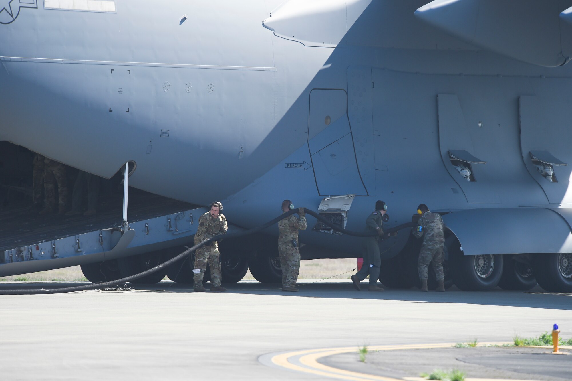 Airmen with the 62nd Operations Group connect a fuel hose to a C-17 Globemaster III during a wet-wing defuel procedure at Joint Base Lewis-McChord, Washington, April 21, 2021, as part of Exercise Rainier War. The exercise tests the 62nd Airlift Wing’s capability to plan, generate and execute a deployment tasking, sustain contingency operations, demonstrate full spectrum readiness while in a contested, degraded and operationally limited environment. (U.S. Air Force photo by Master Sgt. Julius Delos Reyes)