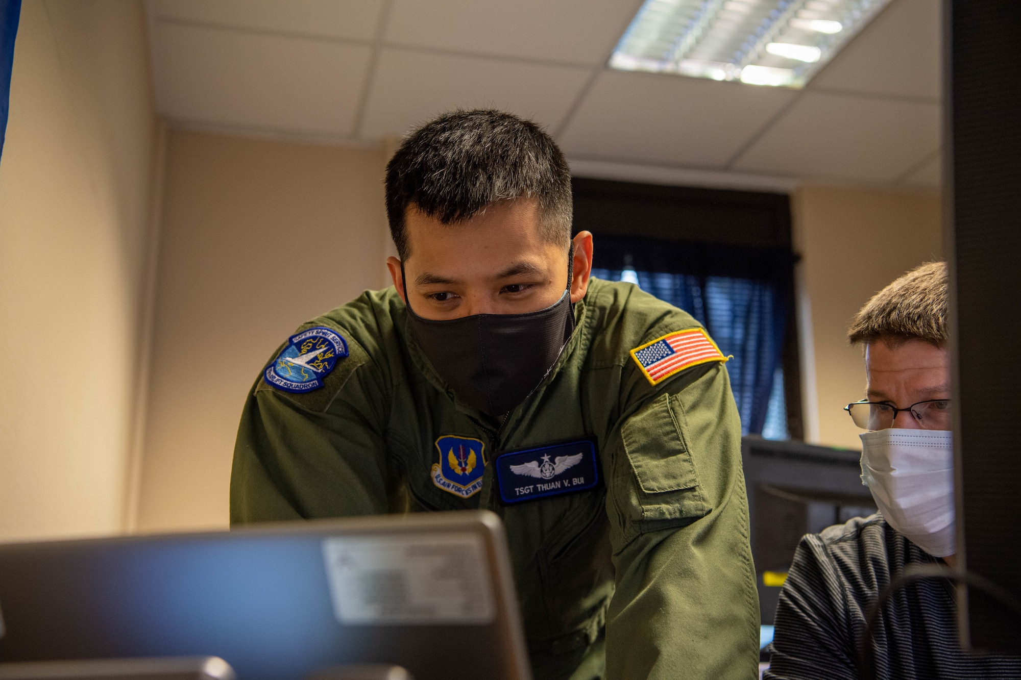 Two Airmen looking at a computer screen