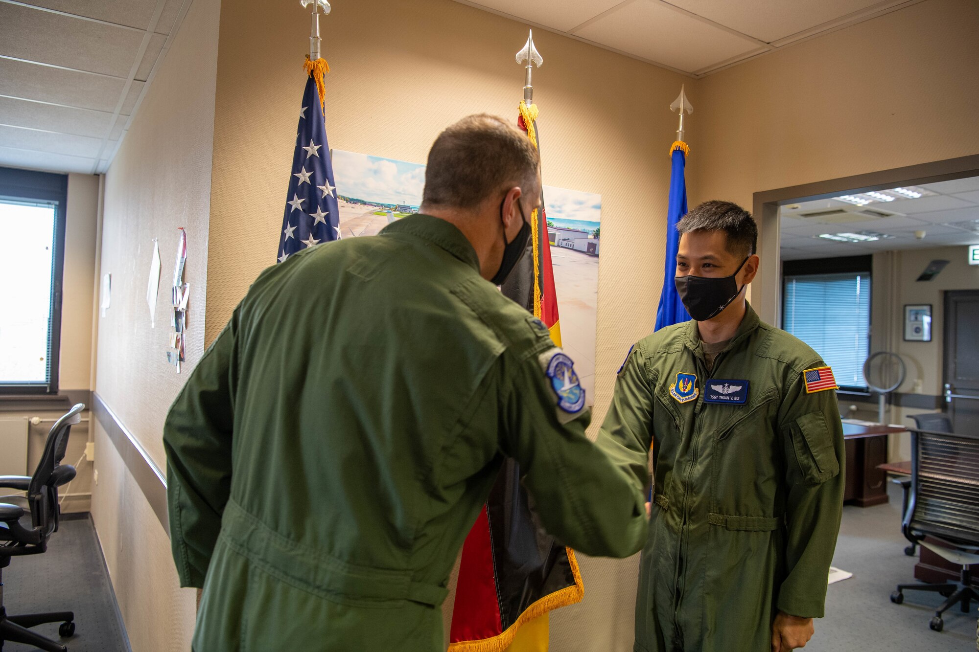 Two Airmen shaking hands.