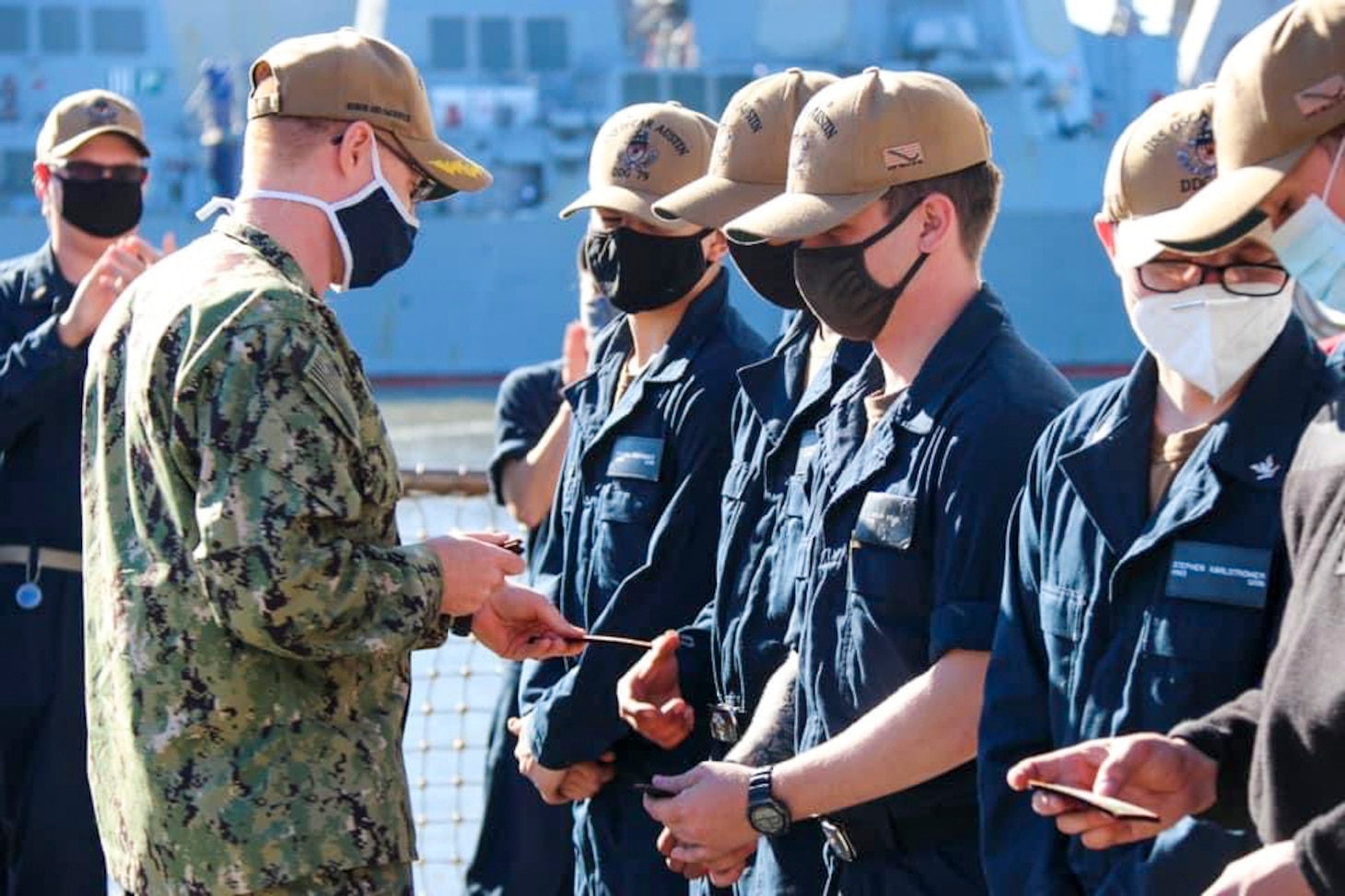NAVAL STATION NORFOLK (April 15, 2021) -  Sailors aboard the Arleigh Burke-class, guided-missile destroyer USS Oscar Austin (DDG 79) receive their command patches during an all-hands call. Newly-reported Sailors undergo a series of evolutions and drills testing their knowledge following command indoctrination. The Sailors then receive their command patch at the completion of drills and evolutions. (U.S. Navy photo courtesy of USS Oscar Austin Public Affairs/Released)