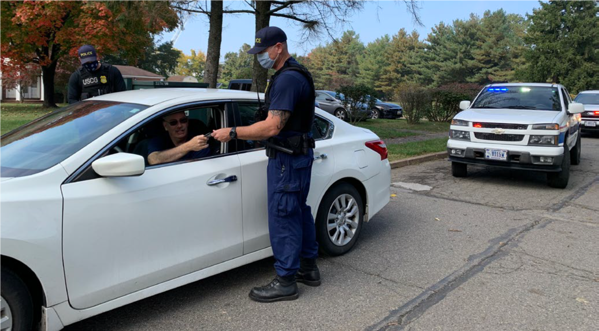 A Coast Guard maritime enforcement specialist conducts ID checks maintaining base security.