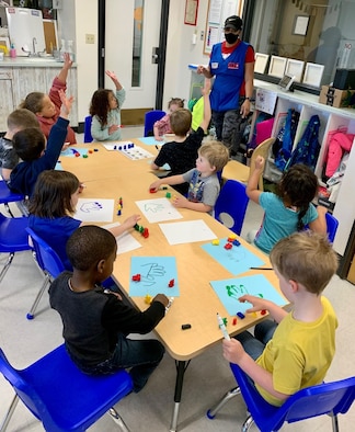 Children seated around a table in a Child Development Center classroom.