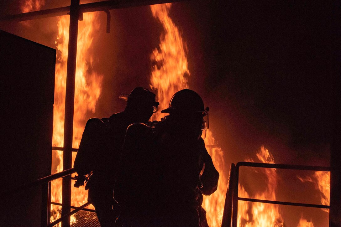 Sailors put out a fire during training.