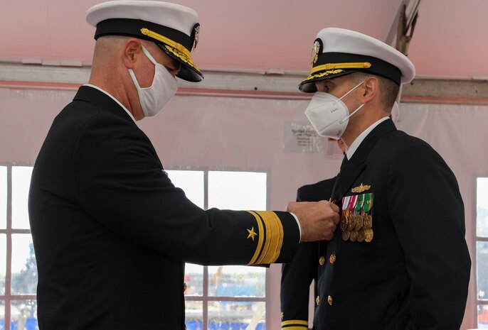 NAVAL STATION NORFOLK – Rear Adm. Brendan McLane, commander, Surface Force Atlantic, awards Cmdr. Matthew Erdner with the Meritorious Service medal during a change of command ceremony on board the Arleigh Burke-class destroyer USS Mason (DDG 87). During the ceremony, Cmdr. Stephen Valerio relieved Erdner of command following at 18-month tour as commanding officer. (U.S. Navy photo by Mass Communication Specialist 2nd Class Jacob Milham/Released)