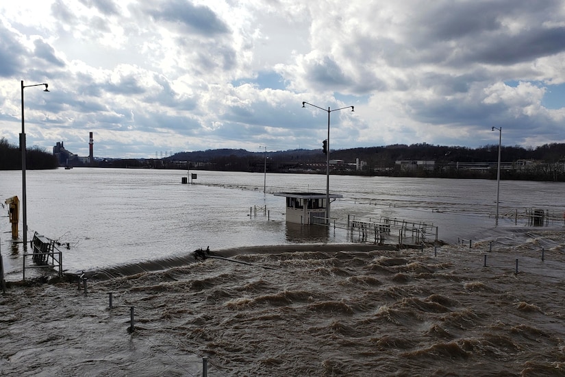 A river flows past a lock and dam.