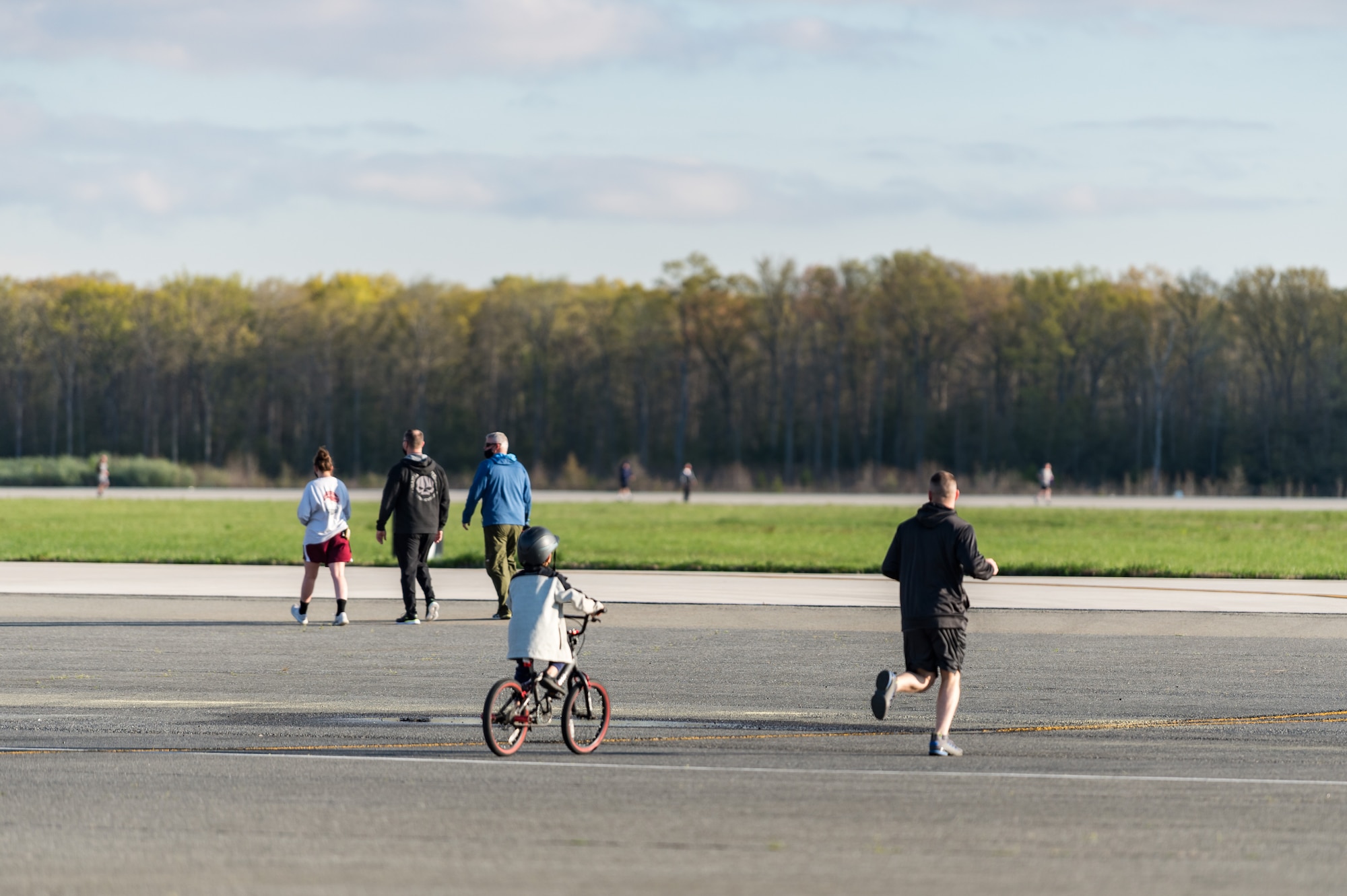 Team Dover members run and ride out to the taxiway and runway during Wingman Day on Dover Air Force Base, Delaware, April 16, 2021. The 2.25-mile run the runway event was one of more than 20 different events held to  promote physical and mental resilience. (U.S. Air Force photo by Roland Balik)