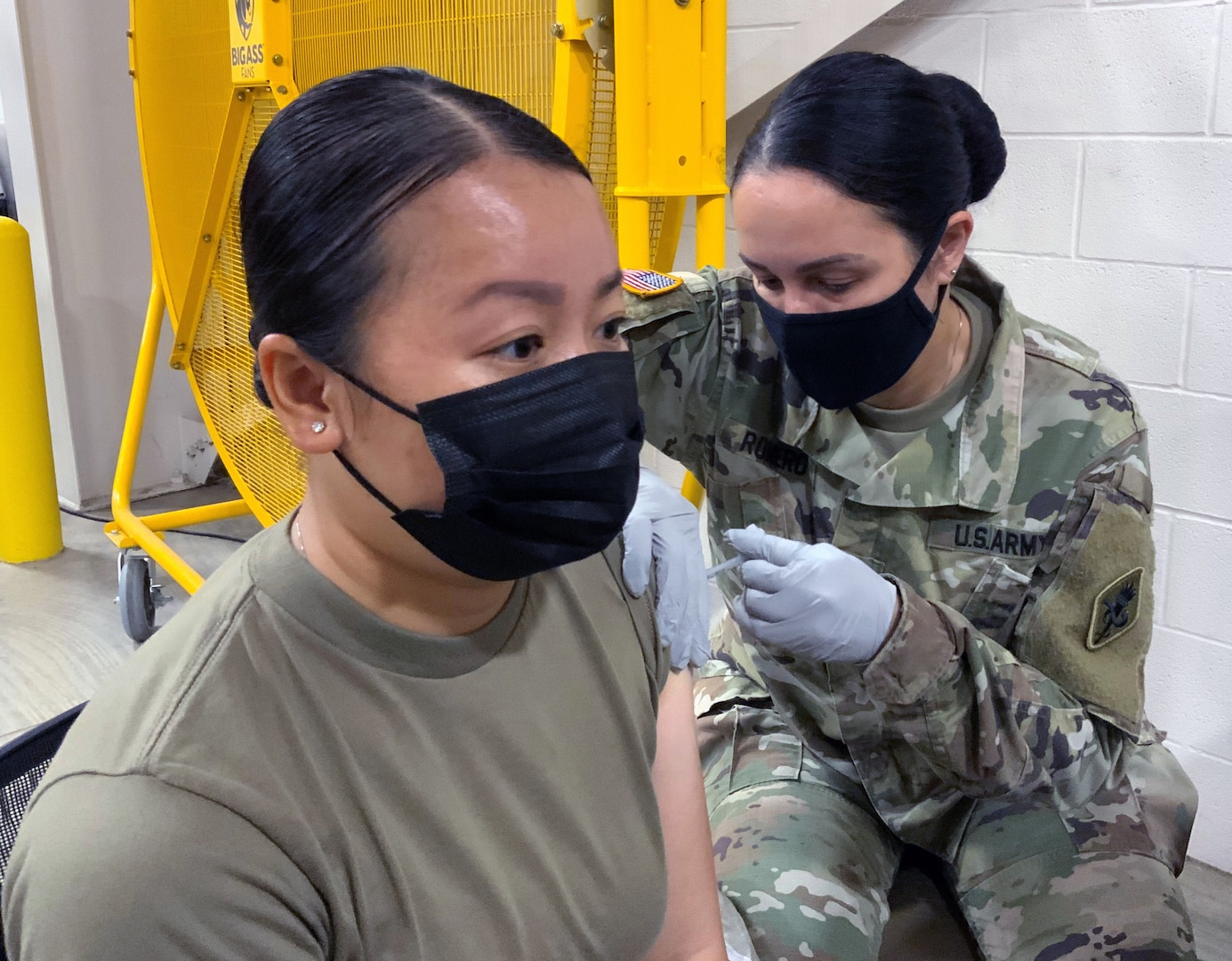 Spc. Hannah Le, 68K medical laboratory specialist in training at the U.S. Army Medical Center of Excellence, or MEDCoE, is administered the first dose of the Pfizer BioNTech COVID-19 vaccine by Sgt. 1st Class Victoria Romero, MEDCoE 68W Combat Medic cadre augmenting staff at the Brooke Army Medical Center’s Joint Base San Antonio-Fort Sam Houston Vaccine site April 15.