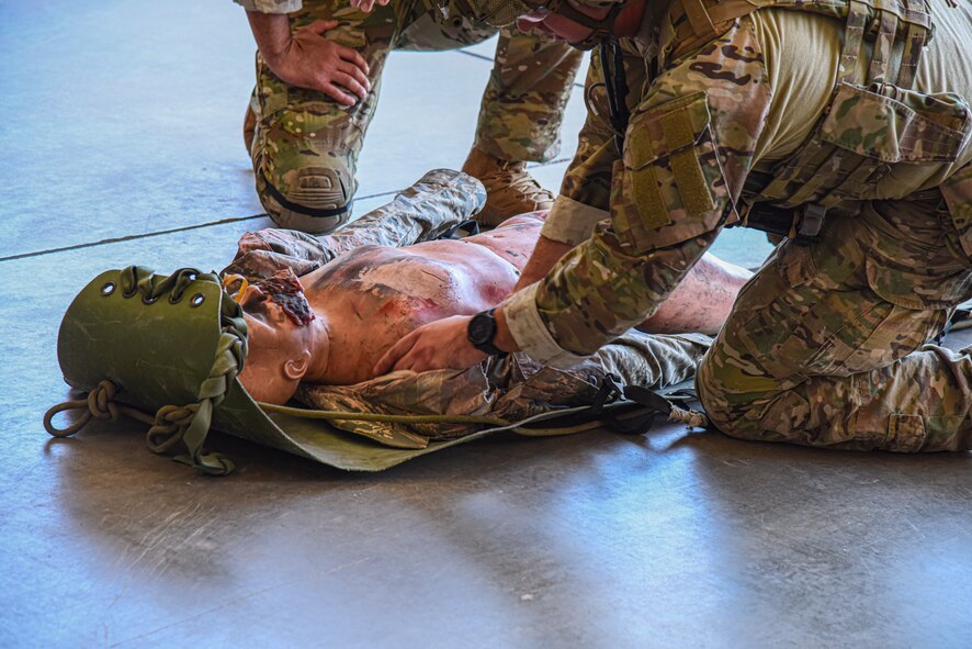 A photo of two airmen practicing first aid on a mannikin