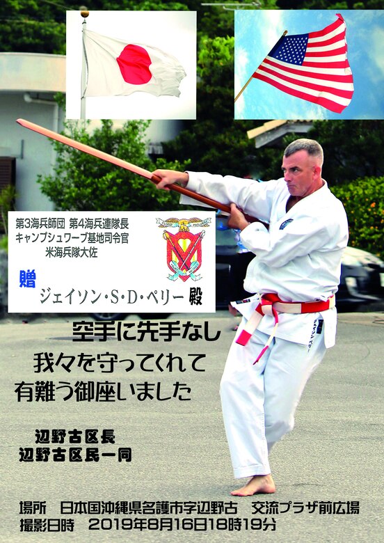 Col. Perry performs Kobudo Eku (boat oar) kata in Mura Odori. The residents of Henoko district presented this picture in the frame to Col. Perry to express their gratitude. PHOTO COURTESY BY ISAO MIYAGI
