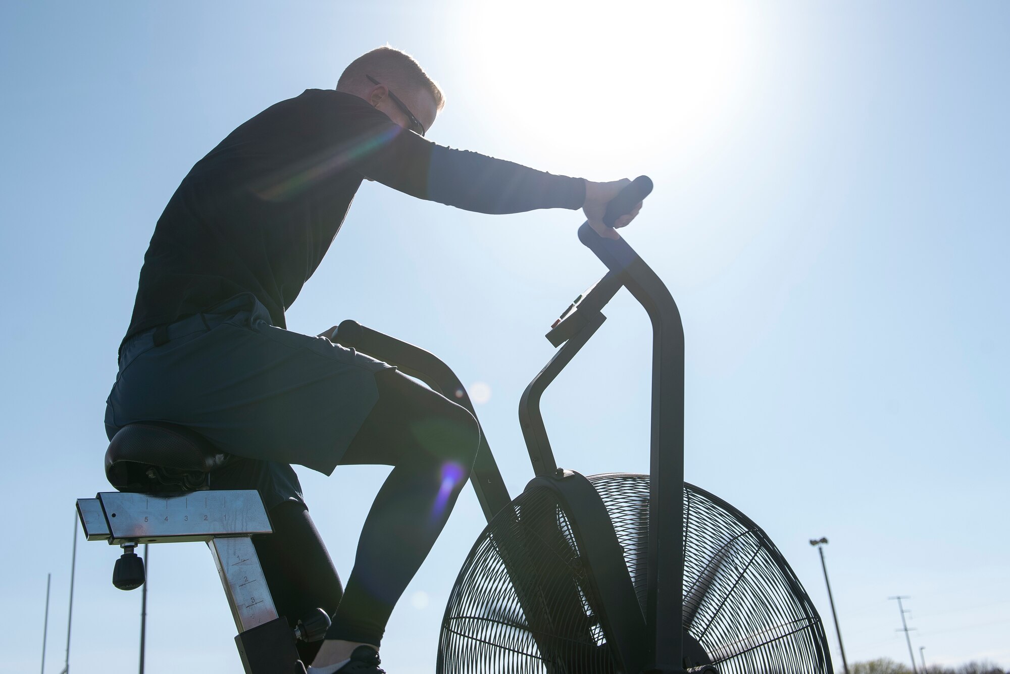 A participant of the 2nd Annual Reaper Smoke Competition & Symposium exercises on an assault bike as part of the fitness competition at Cannon Air Force Base, N.M., April 13, 2021. Reaper Smoke includes 25 different squadrons, from Active Duty, Guard, and Reserve groups. (U.S. Air Force photo by Senior Airman Vernon R. Walter III)