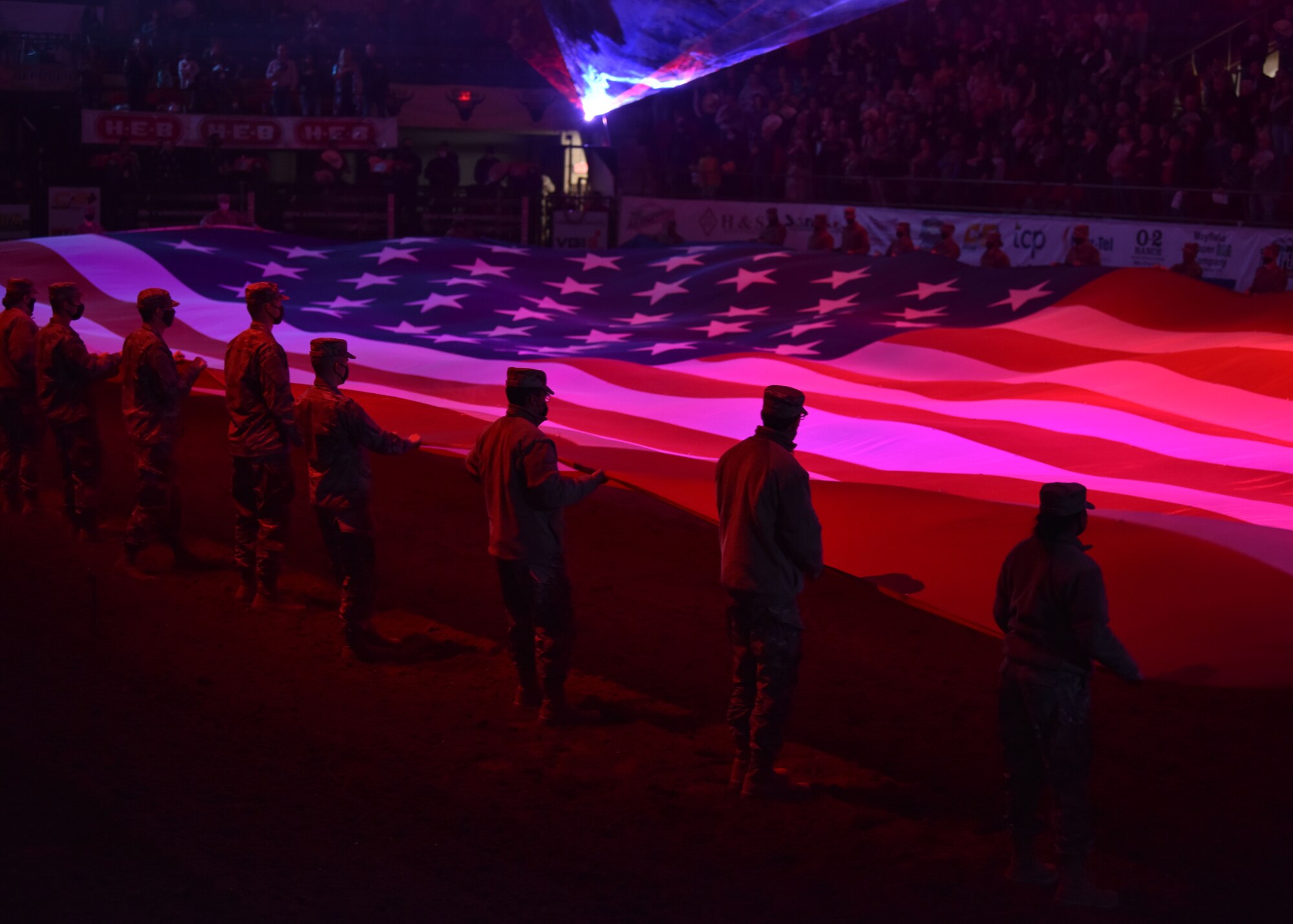 Service members from Goodfellow Air Force Base hold the U.S. flag at the Foster Communications Coliseum in San Angelo, Texas, April 21, 2021. The members held the flag and waved it while the national anthem was sung by Sgt…. as a part of the opening event for Military Appreciation Night. (U.S. Air Force photo by Staff Sgt. Seraiah Wolf)