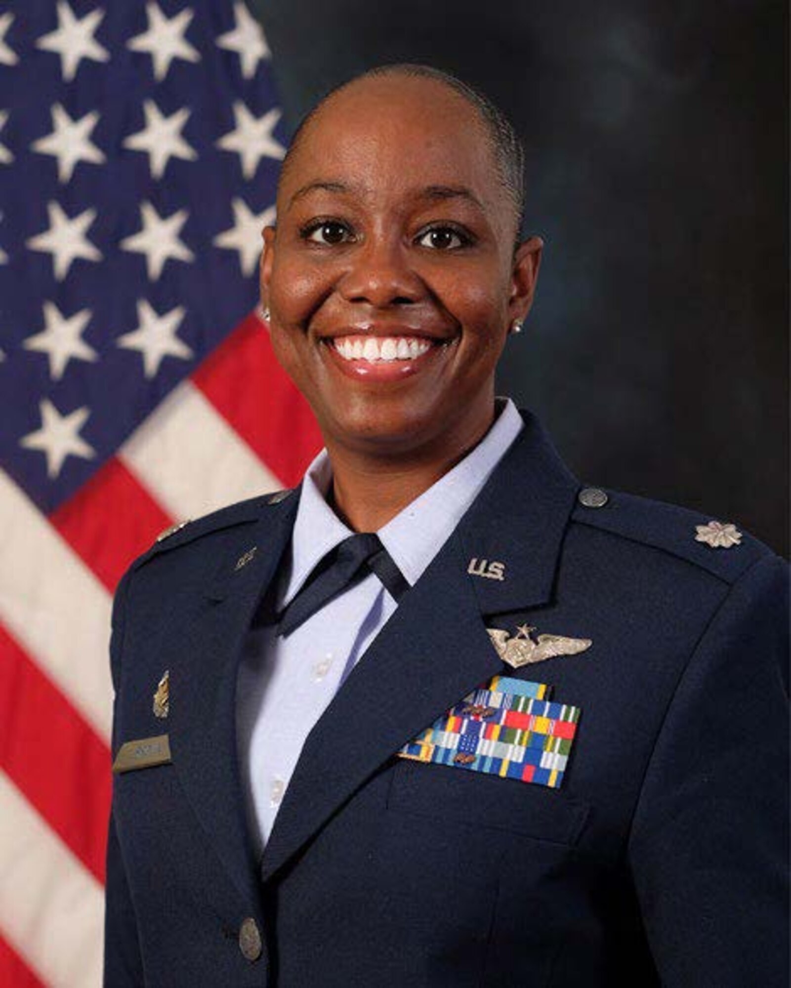 photo of Lt Col Mikita Brown standing in front of U.S. Flag