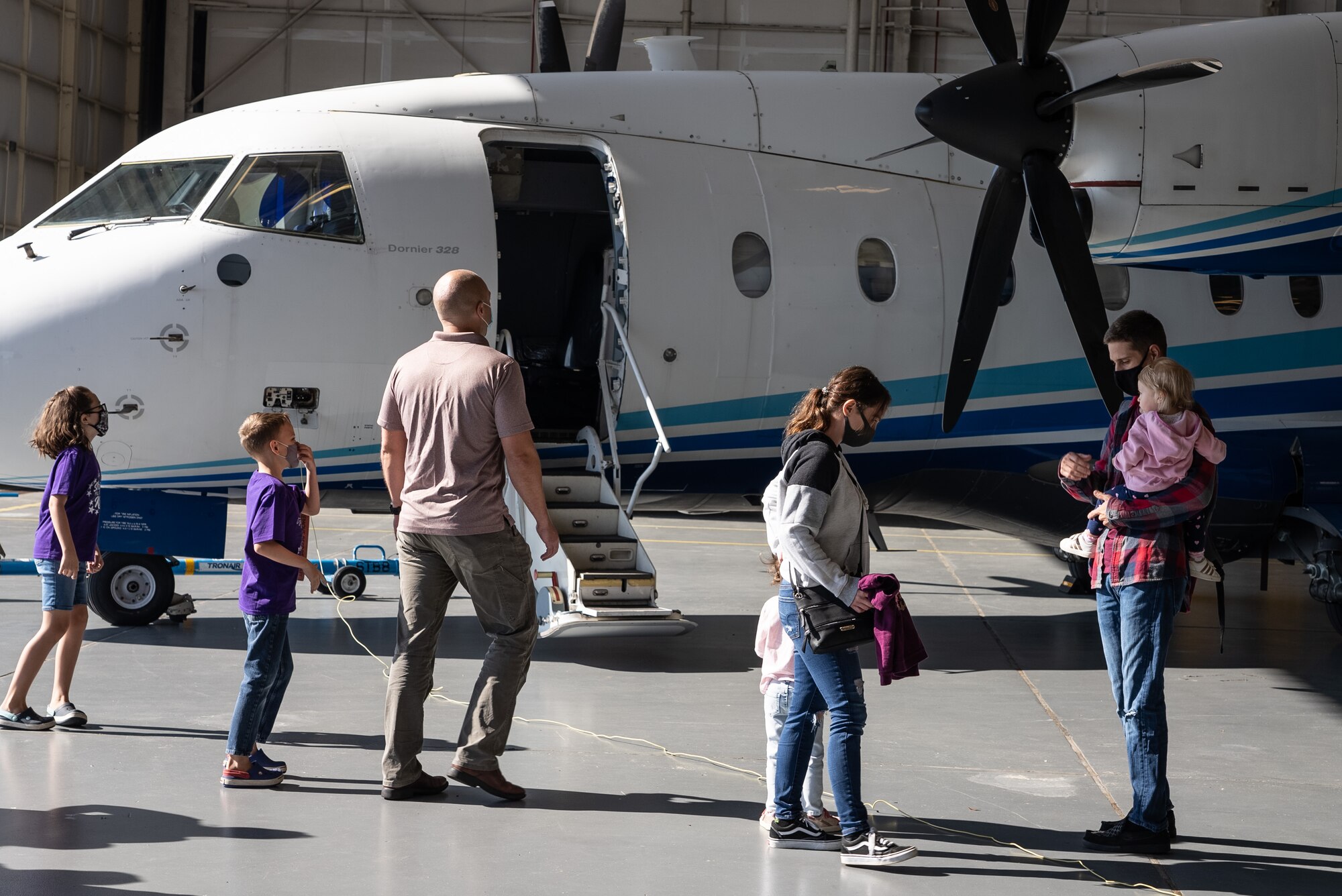 Families walk around a military aircraft.