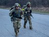 two soldiers march with weapons