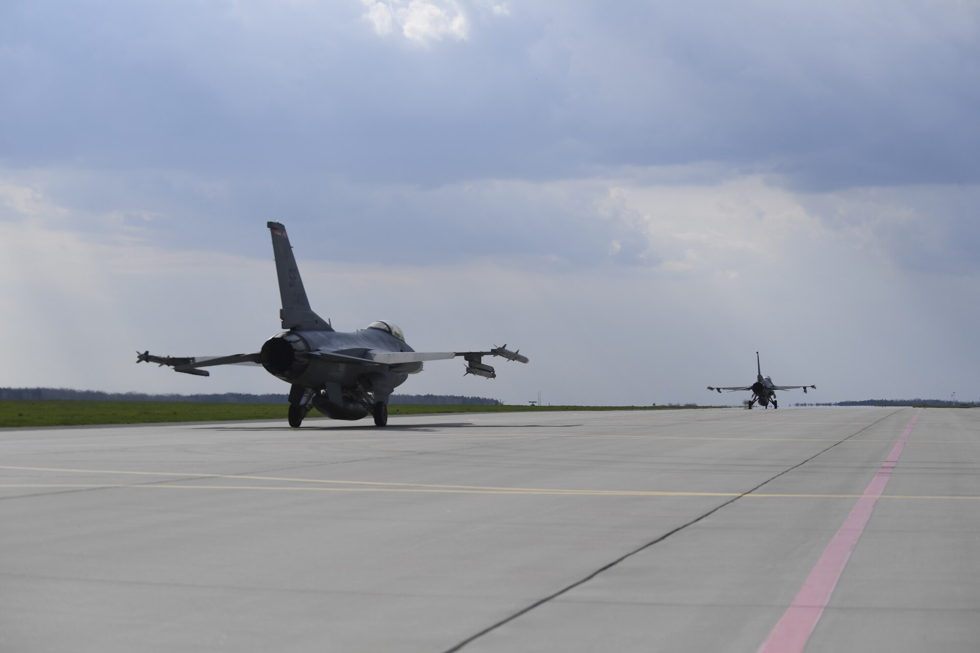Two U.S. Air Force F-16 Fighting Falcon aircraft from the 480th Fighter Squadron prepare to take off during an Agile Combat Employment exercise at Łask Air Base, Poland, April 20, 2021.