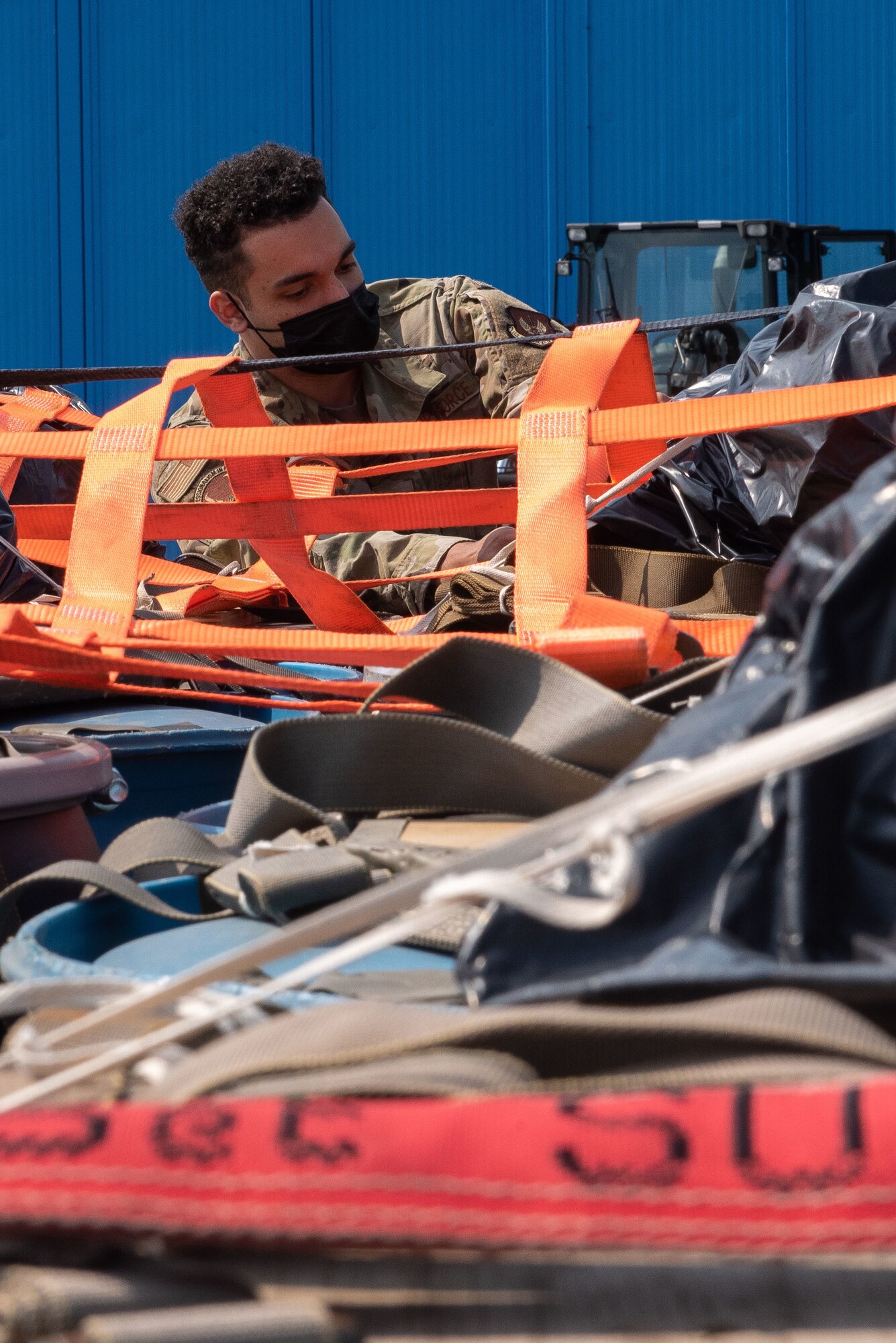 An Airman removes straps from a pallet.