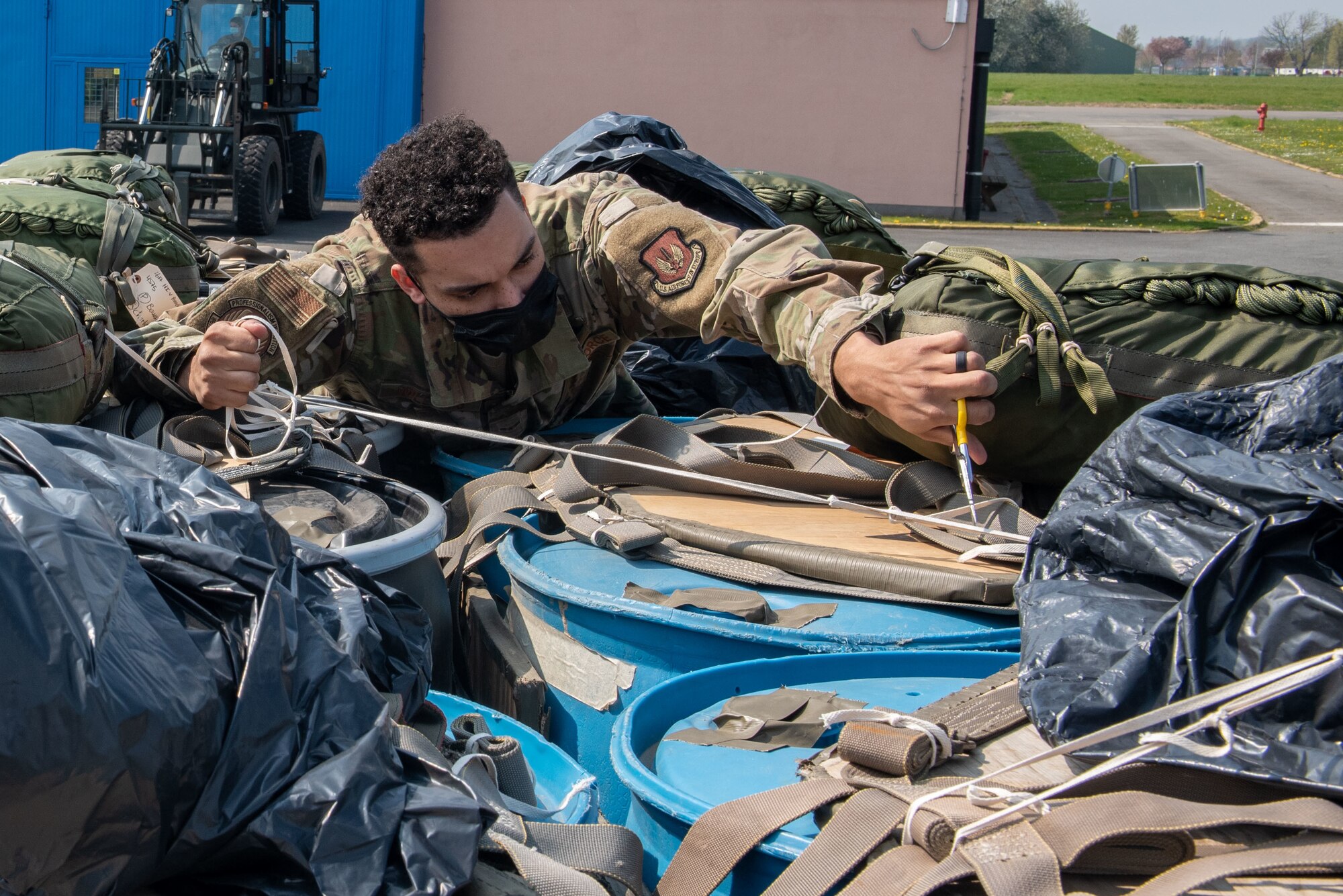 An Airman removes straps from a pallet