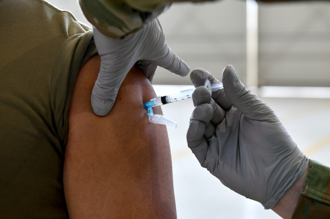 A U.S. Airman receives a COVID-19 vaccination at Aviano Air Base, Italy, April 23, 2021. The 31st MDG holds a vaccination line at Hangar 1 from 8 a.m. to 12:30 p.m. on Fridays to administer Moderna vaccinations to U.S. personnel. (U.S. Air Force photo by Staff Sgt. K. Tucker Owen)