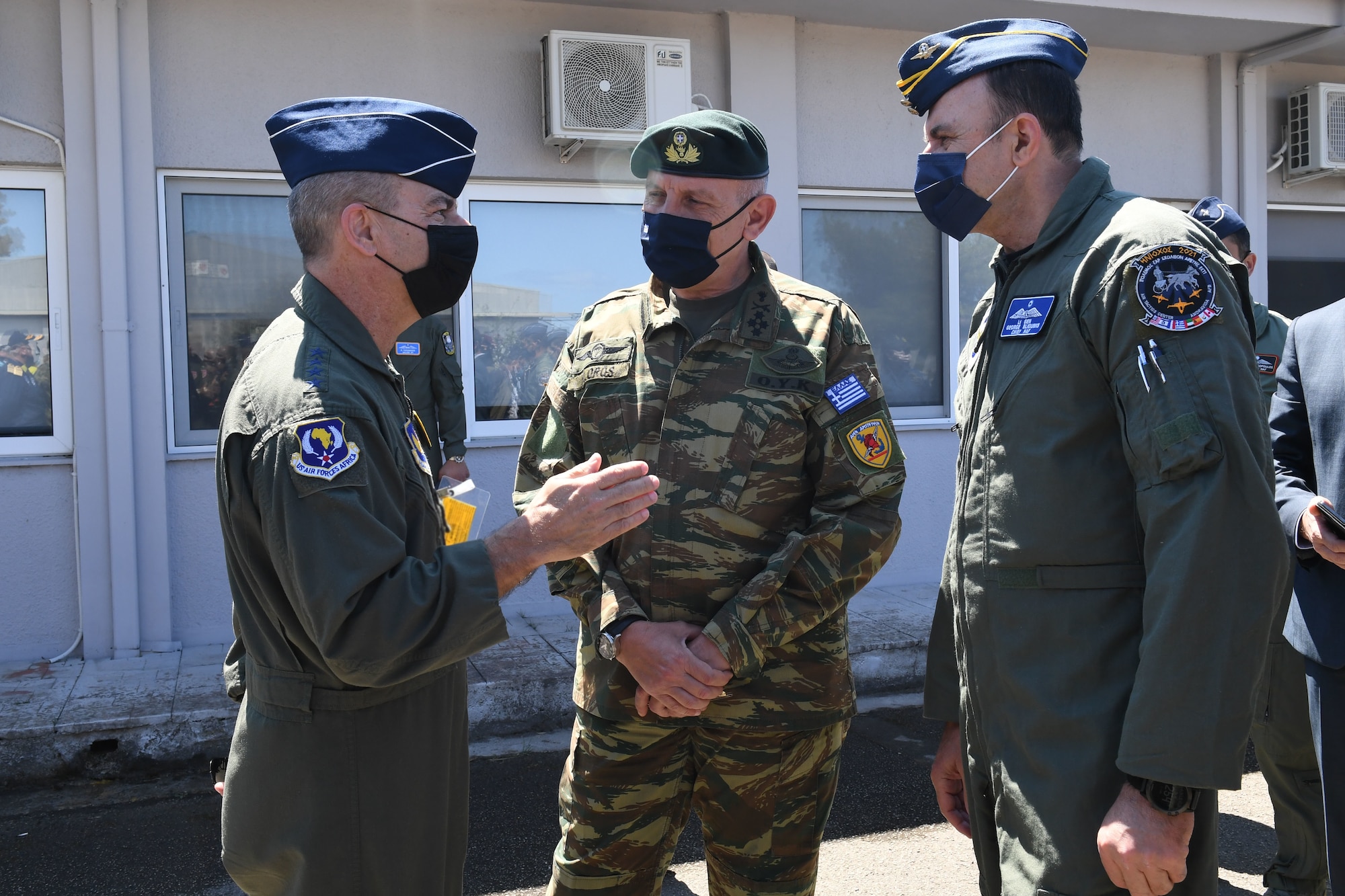 U.S. Air Force Gen. Jeff Harrigian, U.S. Air Forces in Europe and Air Forces Africa commander, left, speaks with Hellenic Air Force Gen. Konstantinos Floros, Chief of Hellenic National Defense General Staff, center, and Hellenic Air Force Lt. Gen. George Blioumis, Chief of Hellenic Air Force General Staff, right, during INIOCHOS 21 at Andravida Air Base, Greece, April 20, 2021. INIOCHOS 21 is an annual exercise in Greece which provides participants the opportunity to develop capabilities in planning and conducting complex air operations in a multinational joint forces environment. The exercise provides advanced and realistic aircrew training to strengthen interoperability of allied and partner air forces. (U.S. Air Force photo by Staff Sgt. Valerie Halbert)