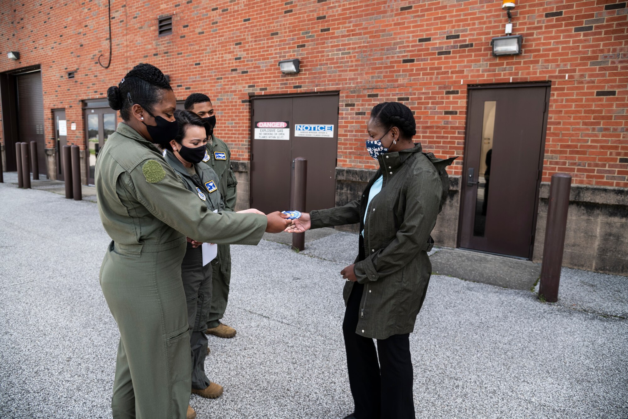 U.S. Air Force Chief Master Sgt. Monica Codner, 73 Airlift Squadron, superintendent, and Senior Master Sgt. Brenda Rodriguez, 54 Airlift Squadron, give their unit patches to Mrs. Kareen Kruzelnick, Air Force spouse, during a tour of the 932nd Airlift Wing at Scott Air Force Base, Illinois, April 10, 2021. Mrs. Kruzelnick  joined her husband, Chief Master Sgt. Brian Kruzelnick, Air Mobility Command command chief, on a tour of the 932nd Airlift Wing. (U.S. Air Force photo by Senior Airman Brooke Spenner)