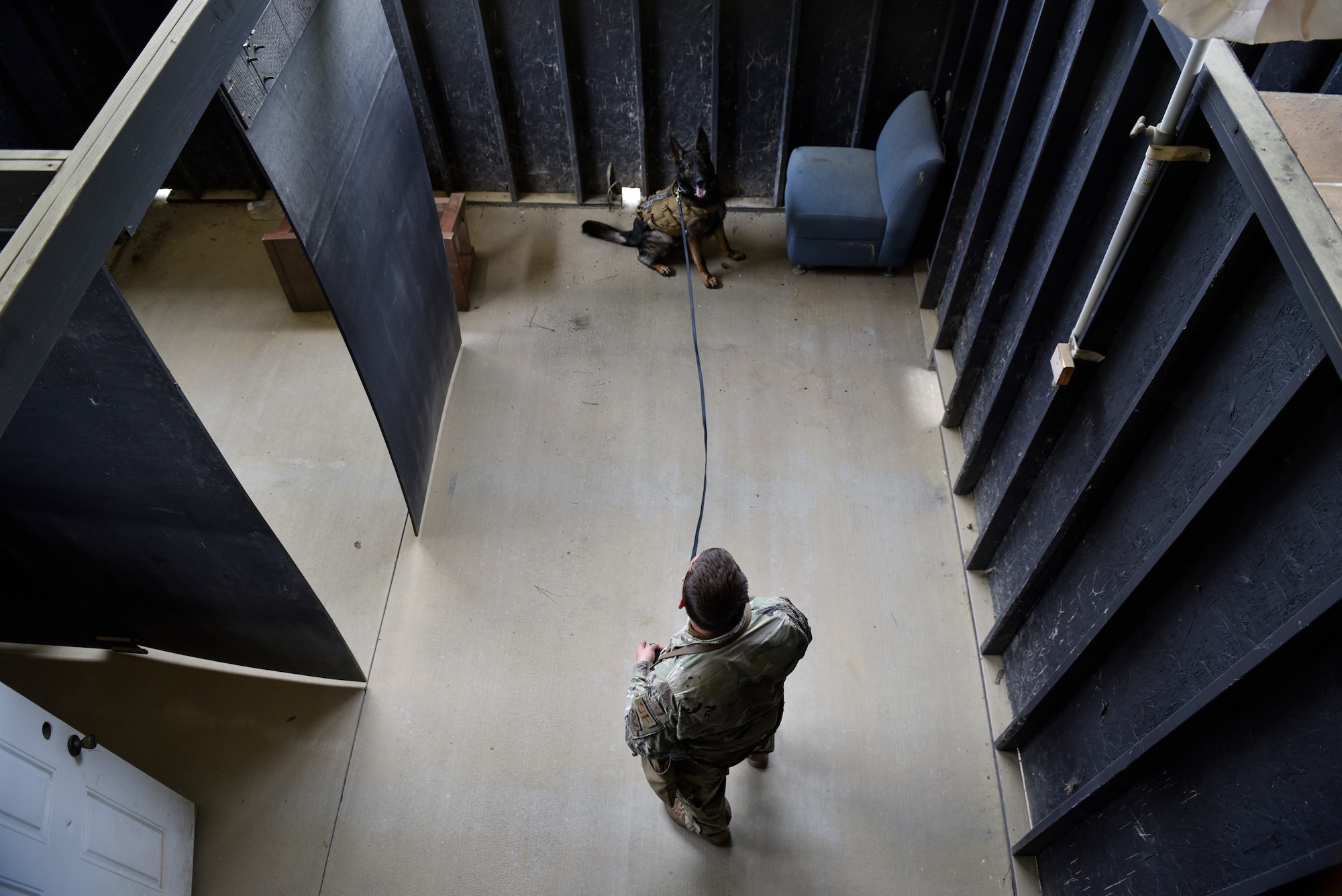 Staff Sgt. Zebulun Hart, 4th Security Forces Squadron military working dog handler, and Derek, 4th SFS MWD, go through a training building to detect narcotics during a joint interagency training day at Seymour Johnson Air Force Base, North Carolina, April 20, 2021. Dog handlers and their dogs from the North Carolina State Bureau of Investigation, the Department of Homeland Security, and the East Carolina University Police Department came to Seymour Johnson AFB to train for the day. (U.S. Air Force photo by Staff Sgt. Kenneth Boyton)