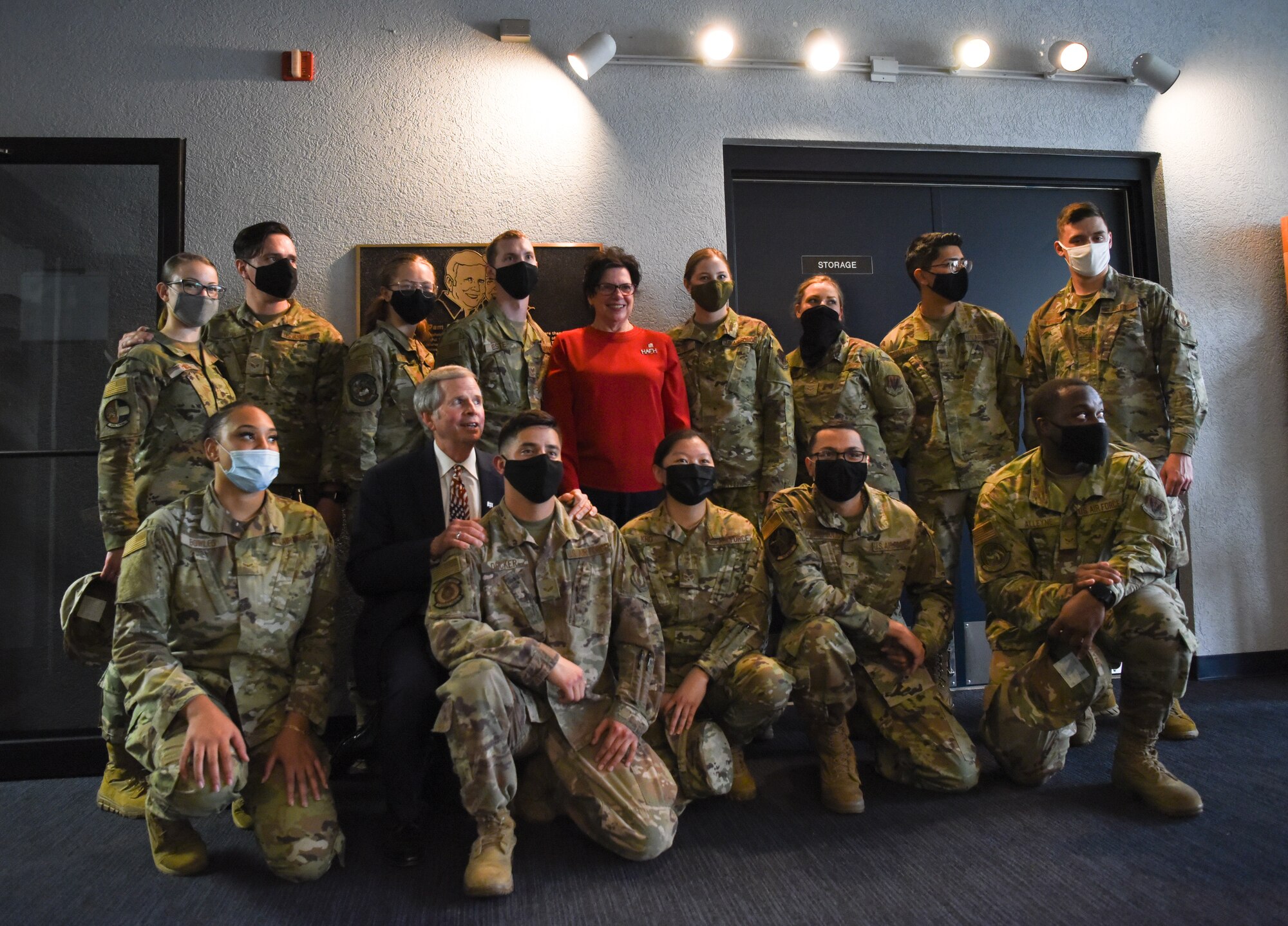 Group of Airmen posing with two community members