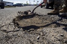 U.S. Service members with base facilities, Marine Corps Base Hawaii, prepare to fill a pot hole, MCBH, April 22, 2021. Base facilities has been working to restore MCBH’s roadways one pot hole at a time. (U.S. Marine Corps photo by Lance Cpl. Samantha Sanchez)