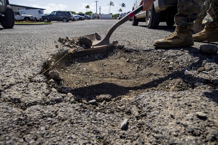 U.S. Service members with base facilities, Marine Corps Base Hawaii, prepare to fill a pot hole, MCBH, April 22, 2021. Base facilities has been working to restore MCBH’s roadways one pot hole at a time. (U.S. Marine Corps photo by Lance Cpl. Samantha Sanchez)