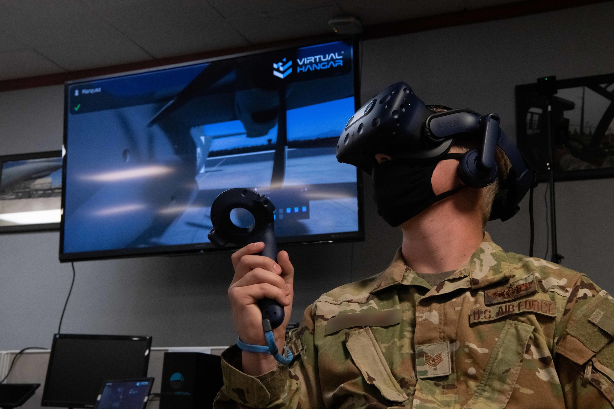 U.S. Air Force Tech. Sgt. Matthew experiences an MC-130J Commando II virtual reality maintenance training program during an Air Education and Training Command Integrated Technology Platform demonstration April 15, 2021, at Cannon Air Force Base, N.M. ITP team members from around the Air Force showed event attendees how VR training programs have already benefitted other squadrons and are ready for rapid acquisition and assimilation into current aircraft maintenance operations. (U.S. Air Force photo illustration by Staff Sgt. Peter Reft/photo manipulated for operational security)