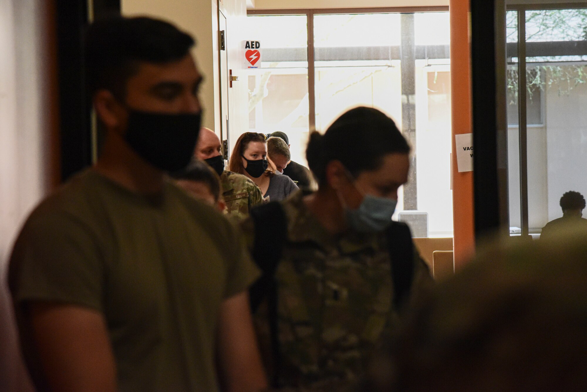 A photo of servicemembers waiting in line to receive a vaccine.