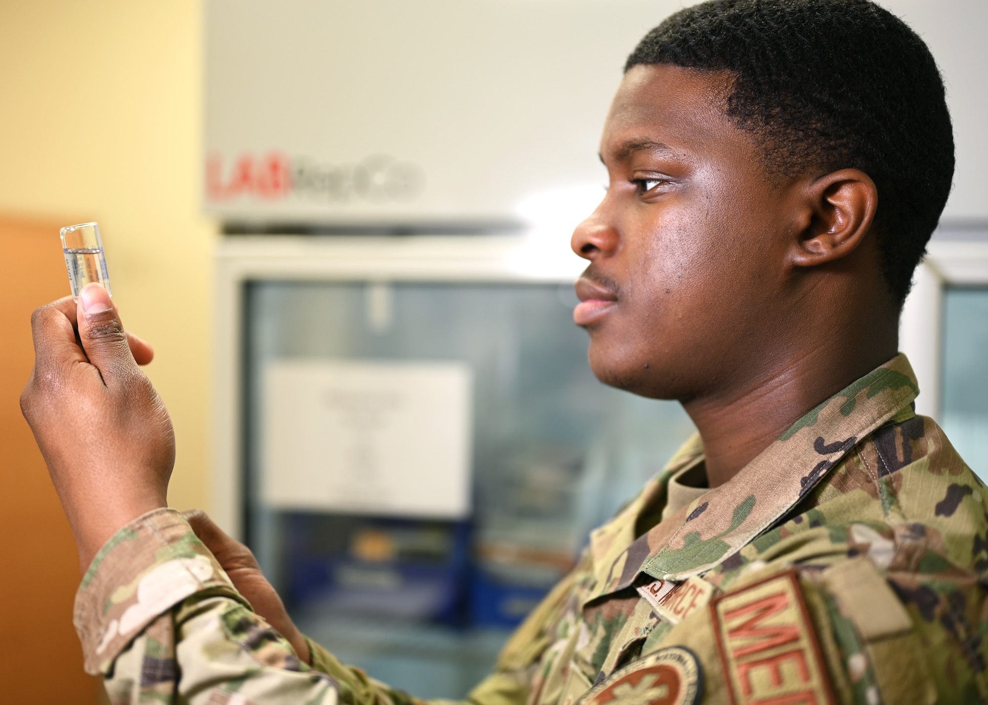 U.S. Air Force Senior Airman Micah Savage, 17th Medical Group immunizations technician, inspects a vial of saline during a demonstration of how vaccines are prepared for injection at the Ross Clinic on Goodfellow Air Force Base, Texas, April 19, 2021. Savage was entrusted as an immunizations technician to administer various vaccines to the base population. (U.S. Air Force photo by Airman 1st Class Michael Bowman)