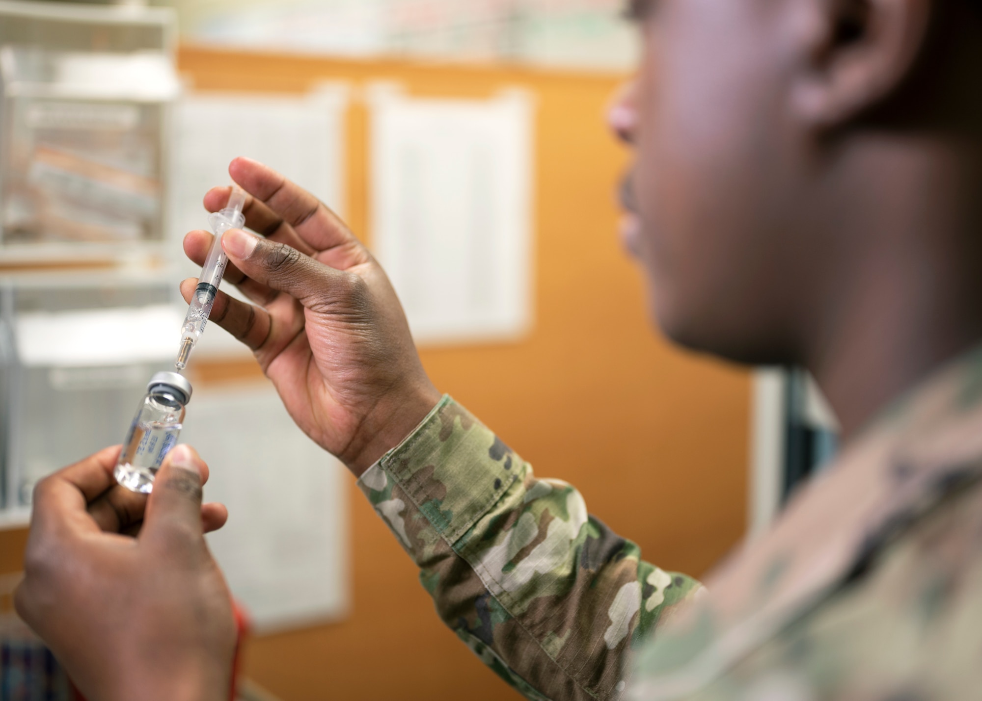 U.S. Air Force Senior Airman Micah Savage, 17th Medical Group immunizations technician, fills a syringe with saline as a part of his demonstration at the Ross Clinic on Goodfellow Air Force Base, Texas, April 19, 2021. Savage was in charge of ensuring vaccines were administered safely and correctly to all immunizations patients. (U.S. Air Force photo by Airman 1st Class Michael Bowman)