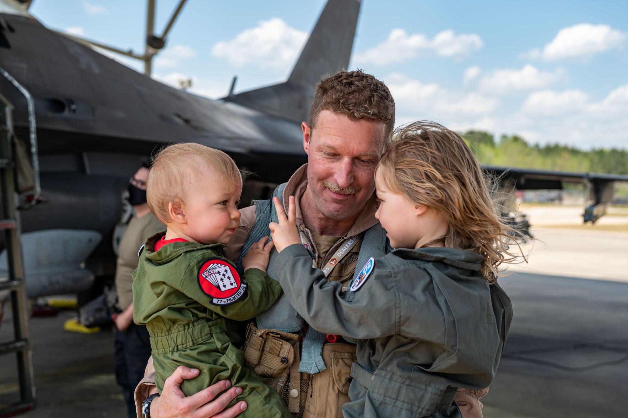 A photo of a pilot embracing children.