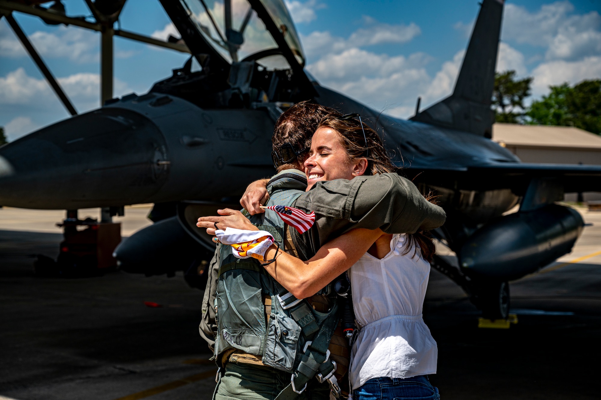 A photo of a pilot embracing a family member on the flightline.