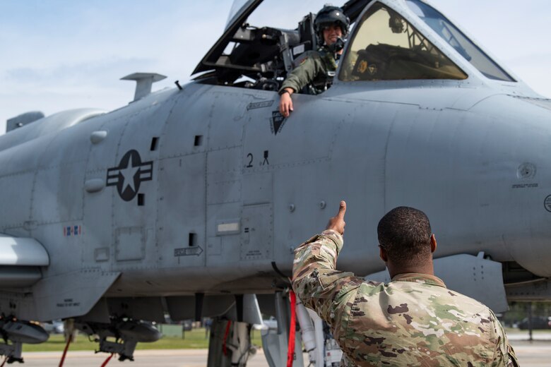 A photo of an Airman giving a thumbs up to a pilot