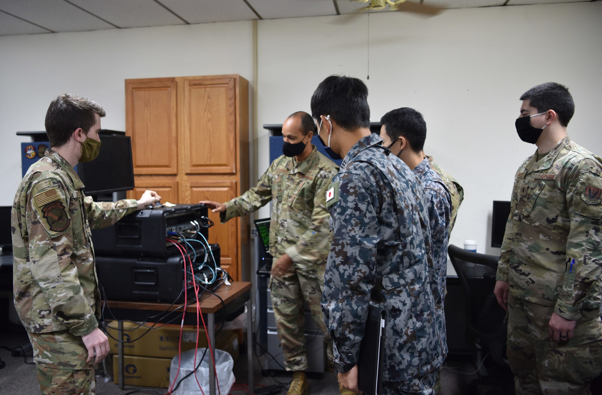 Senior Airman Gabriel Coleman, 552 Air Control Networks Squadron, and Master Sgt. Christopher Bailey, Pacific Air Command A3/6, explain the capabilities of a deployable cyber defense weapon system, Cyberspace Vulnerability Assessment/Hunter, to Lt. Col. Akio Ohigashi and Capt. Shumpei Kawano from the Japanese Air Self-Defense Force. The system is used by the 552 ACNS Mission Defense Team to defend the 552nd Air Control Wing's Control & Reporting Centers and E-3 fleet and ground systems from cyber threats. (Air Force photo by Kimberly Woodruff)