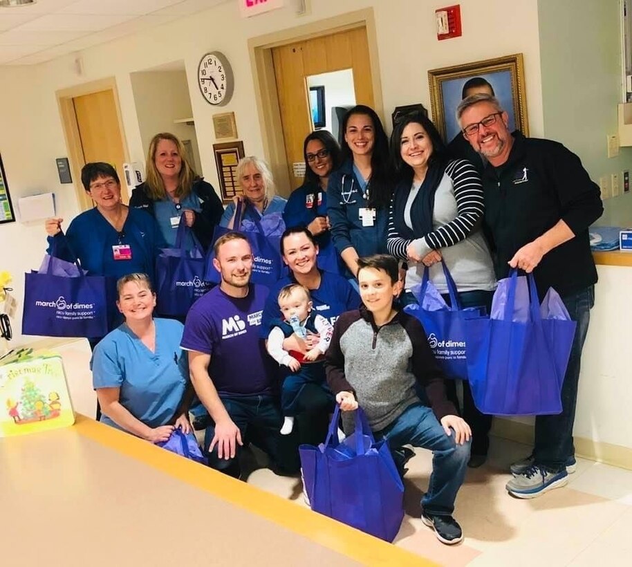 U.S. Air Force Master Sgt. Jessica Roy (center), 103rd Security Forces Squadron S2 intelligence and investigations superintendent and antiterrorism program manager, Marc Spencer (right), and their families deliver gift bags to nurses at the Saint Francis Hospital neonatal intensive care unit in Hartford, Connecticut, on World Prematurity Day, November 17, 2019. Roy and Spencer both had infant sons pass away after being born prematurely and have dedicated the following years to advocacy work with the March of Dimes organization. (Courtesy photo)