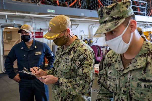 Capt. Todd Whalen, chief of staff, Naval Surface Force Atlantic fills out forms prior to receiving the COVID-19 vaccine aboard the San Antonio-class amphibious transport dock ship USS Arlington (LPD 24), April 23, 2021.