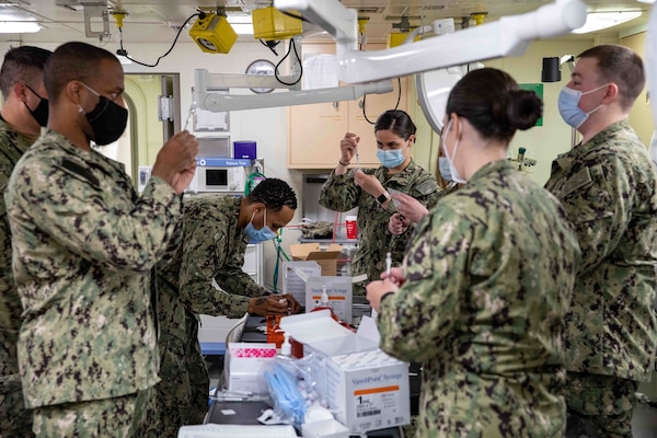 Sailors assigned to Fleet Surgical Teams 2, 4, and 8 prepare COVID-19 vaccines aboard the San Antonio-class amphibious transport dock ship USS Arlington (LPD 24), April 23, 2021.