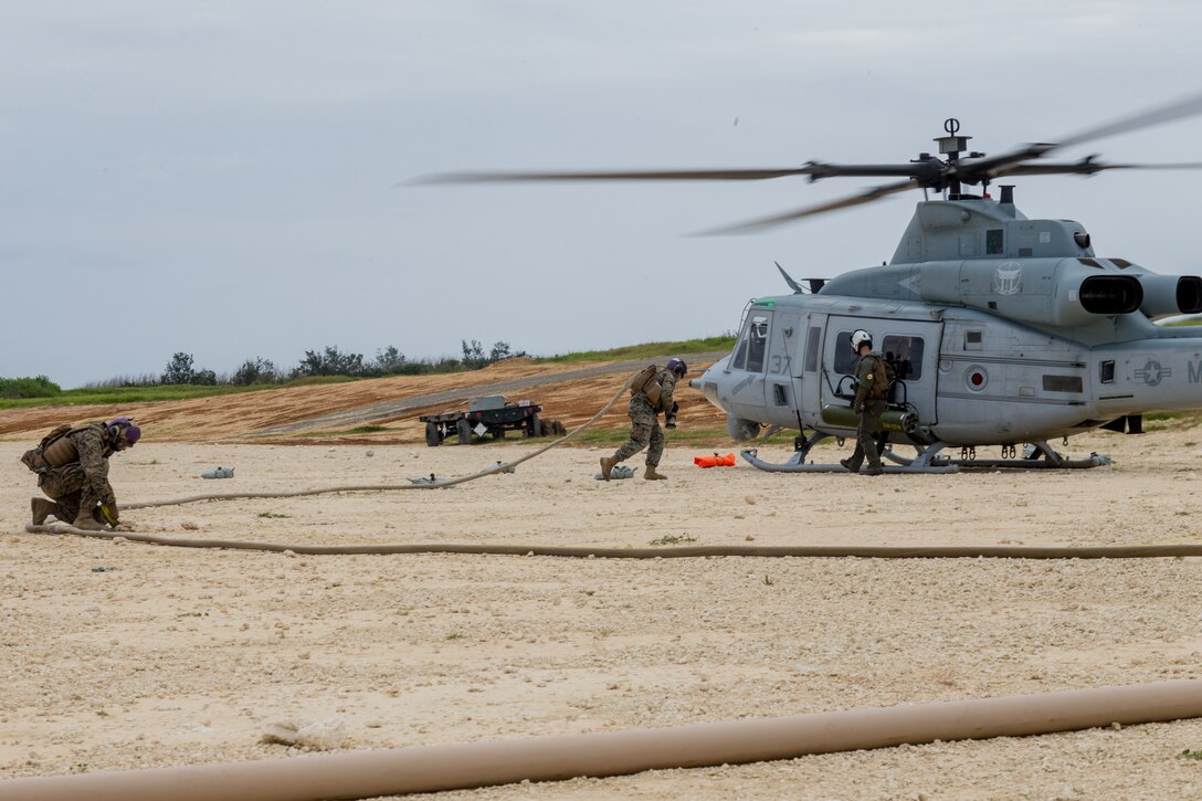 U.S. Marines with Marine Wing Support Squadron (MWSS) 172 prepare to refuel a UH-1Y Venom helicopter assigned to Marine Light Helicopter Squadron (HMLA) 267 during a forward arming and refueling point training event as part of a Marine Corps combat readiness evaluation (MCCRE) held by MWSS-172 at the Ie Shima training facility, Okinawa, Japan, April 15, 2021. The MCCRE creates a challenging, realistic training environment that produces combat-ready forces capable of operating as a deployed unit at any time. (U.S. Marine Corps photo by Lance Cpl. Justin J. Marty)