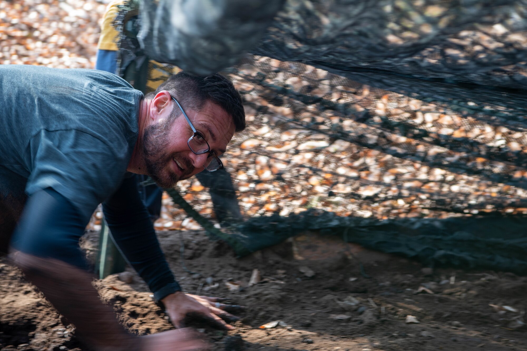 Airman crawls in the mud