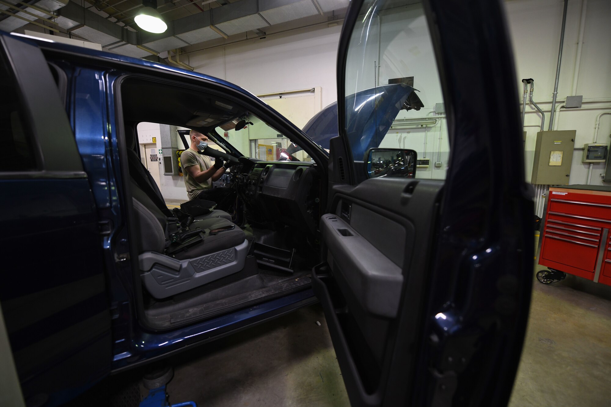 Airman 1st Class Korey Sarantopoulos, 31st Logistics Readiness Squadron vehicle maintenance technician, repairs a government vehicle at Aviano Air Base, Italy, April 20, 2021. Sarantopoulos repaired the heat, ventilation, and air conditioning system of a Ford F-150 truck. The 31st LRS delivers and sustains combat logistics readiness support through professional vehicle, supply and fuels management. (U.S. Air Force photo by Senior Airman Ericka A. Woolever)