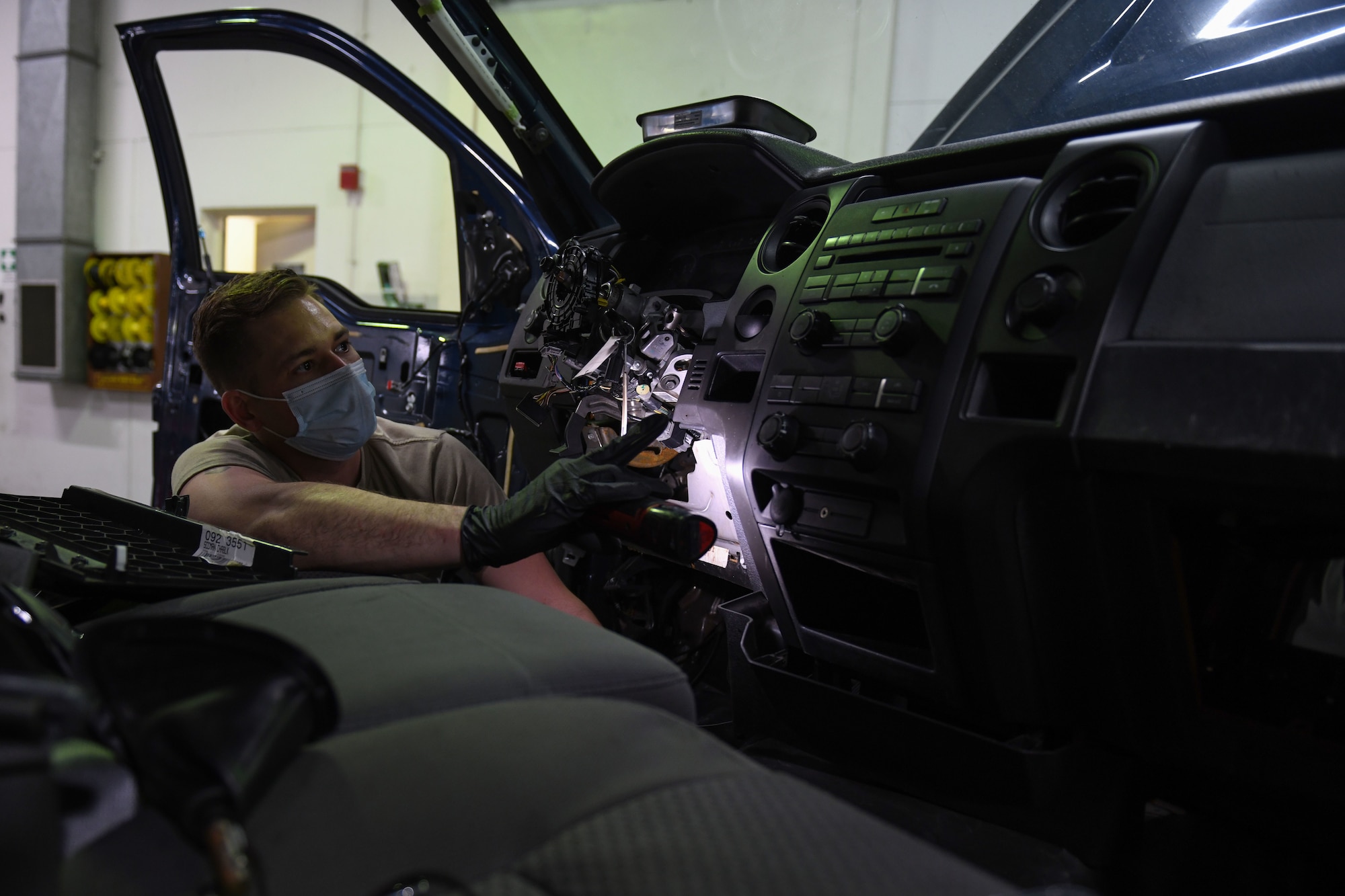 Airman 1st Class Korey Sarantopoulos, 31st Logistics Readiness Squadron vehicle maintenance technician, inspects a Ford F-150 truck at Aviano Air Base, Italy, April 20, 2021. Sarantopoulos repaired the heat, ventilation, and air conditioning (HVAC) system of a government vehicle. Sarantopoulos extracted multiple parts of the vehicle, such as the steering wheel and radio to repair the HVAC system. (U.S. Air Force photo by Senior Airman Ericka A. Woolever)