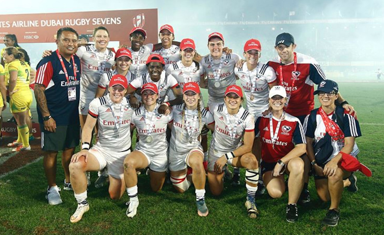 A women’s rugby team poses for a photo.