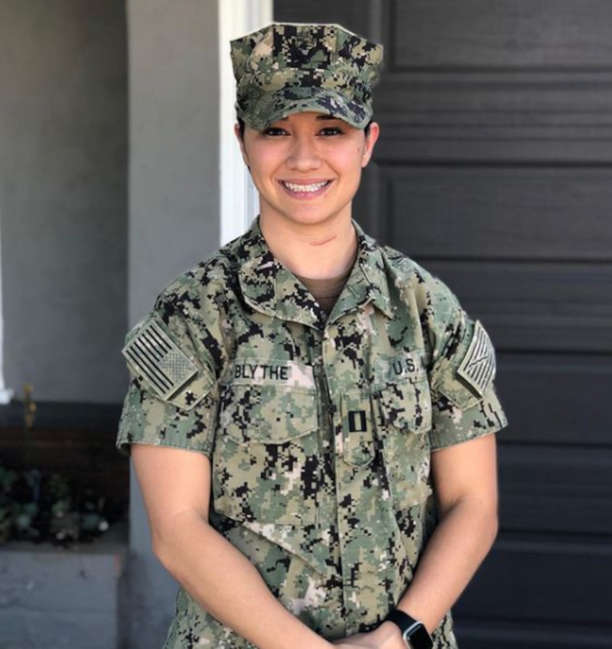 A woman in a Navy uniform poses for a photo.
