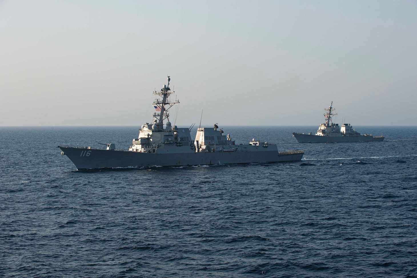 USS Thomas Hudner (DDG 116) and USS Laboon (DDG 58) sail in formation alongside the aircraft carrier USS Dwight D. Eisenhower (CVN 69) in the Arabian Sea.