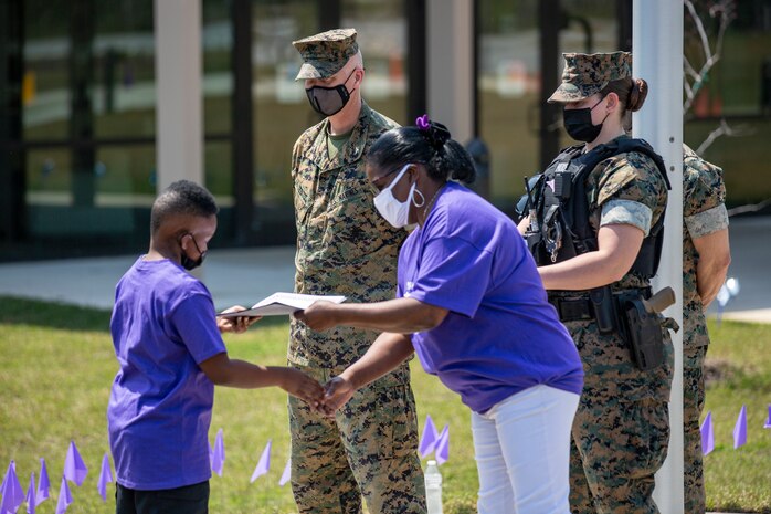 U.S. Marine Corps Col. Curtis V. Ebitz, center, the commanding officer of Marine Corps Air Station New River, participates in an award ceremony at Delalio Elementary School on MCAS New River, North Carolina, April 8, 2021. April is the month of the military child, highlighting the important role military children play in the armed forces community. (U.S. Marine Corps photo by Lance Cpl. Isaiah Gomez)
