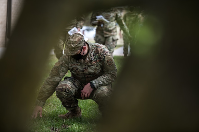 Senior Airman James Herndon, 22nd Force Support Squadron services journeyman, participates in a search and recovery effort during an exercise April 22, 2021, at McConnell Air Force Base, Kansas. The team moves in sync to ensure all belongings are properly tagged and recovered so casualties can be identified. (U.S. Air Force photo by Senior Airman Alan Ricker)