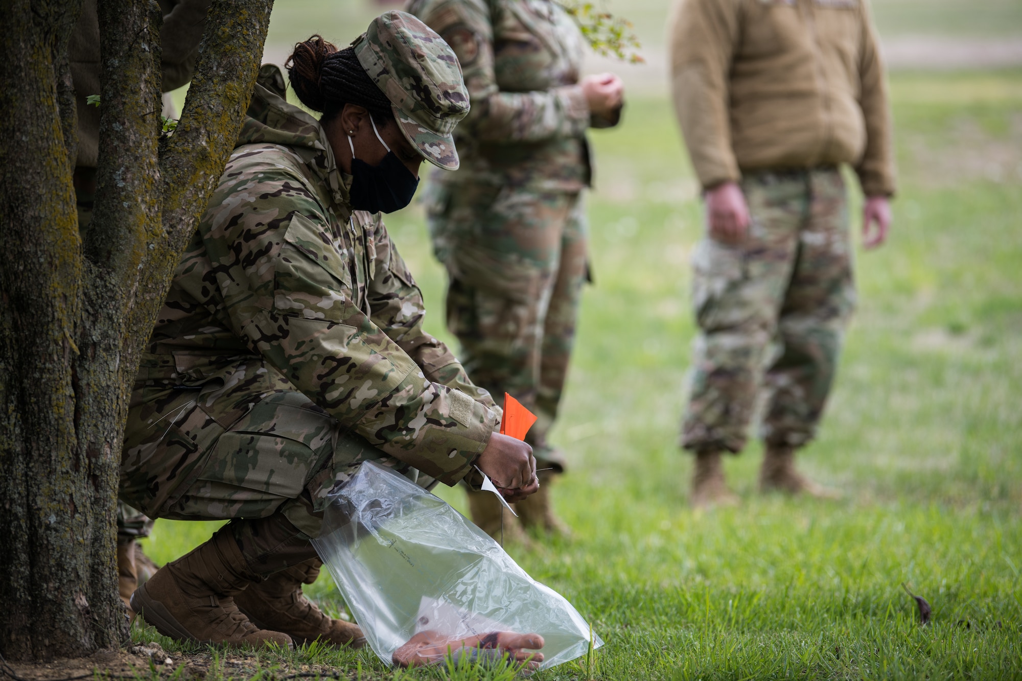 Senior Airman Tierra Brown, 22nd Force Support Squadron storeroom manager, tags the location of simulated remains during an exercise April 22, 2021, at McConnell Air Force Base, Kansas. When an object is found, the team will pause to allow proper handling and tagging, ensuring the item is recovered before departing the scene. (U.S. Air Force photo by Senior Airman Alan Ricker)